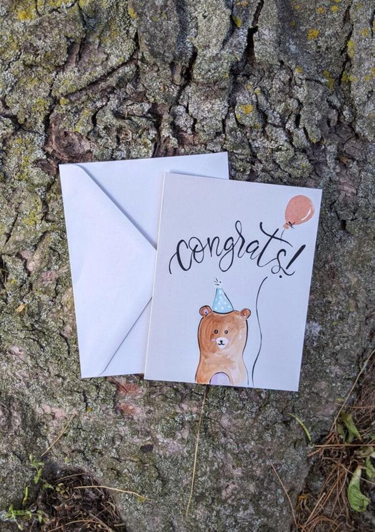 Hand Painted Congratulations Card, Unique Grad Gift, Bear with Balloon, Blank Inside Graduation Greeting Card | MakerPlace by Michaels Hand Painted Congratulations Card, Unique Grad Gift, Bear with Balloon, Blank Inside Graduation Greeting Card | MakerPlace by Michaels